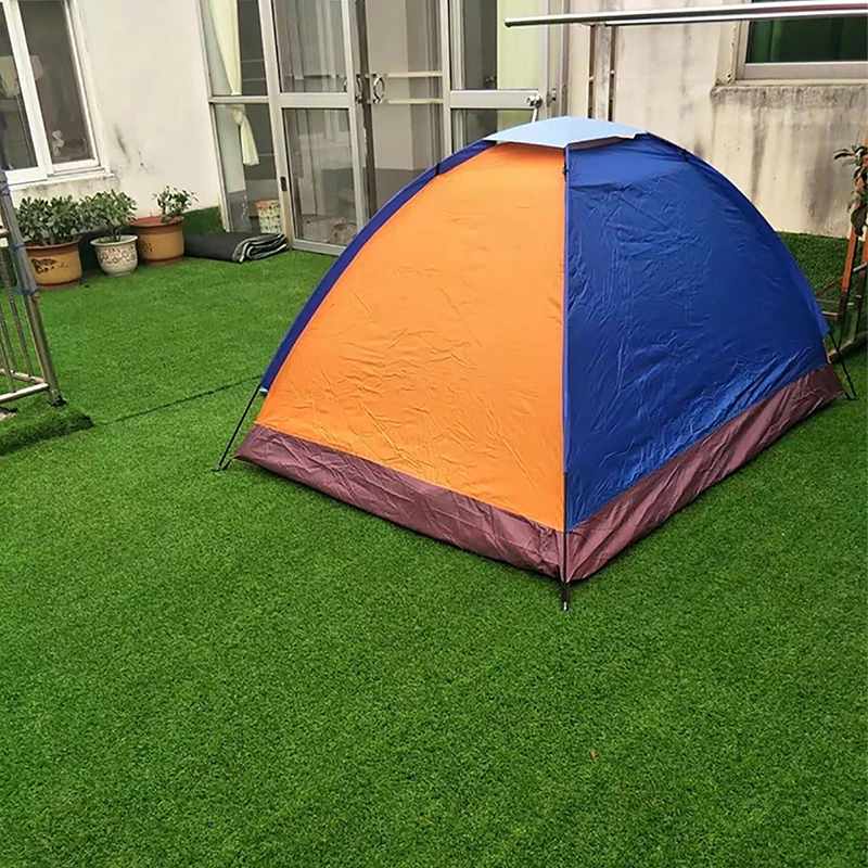 A blue and orange camping tent pitched on a lush green balcony lawn made of high quality astro turf, showcasing a comfortable home outdoor leisure space banner