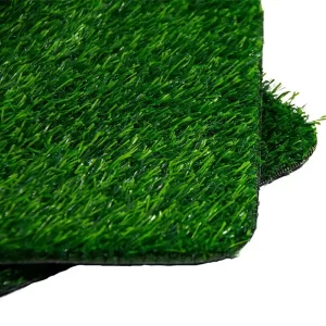 Close-up of premium non-toxic artificial grass samples for commercial landscaping, featuring high-density green fibers and durable backing banner