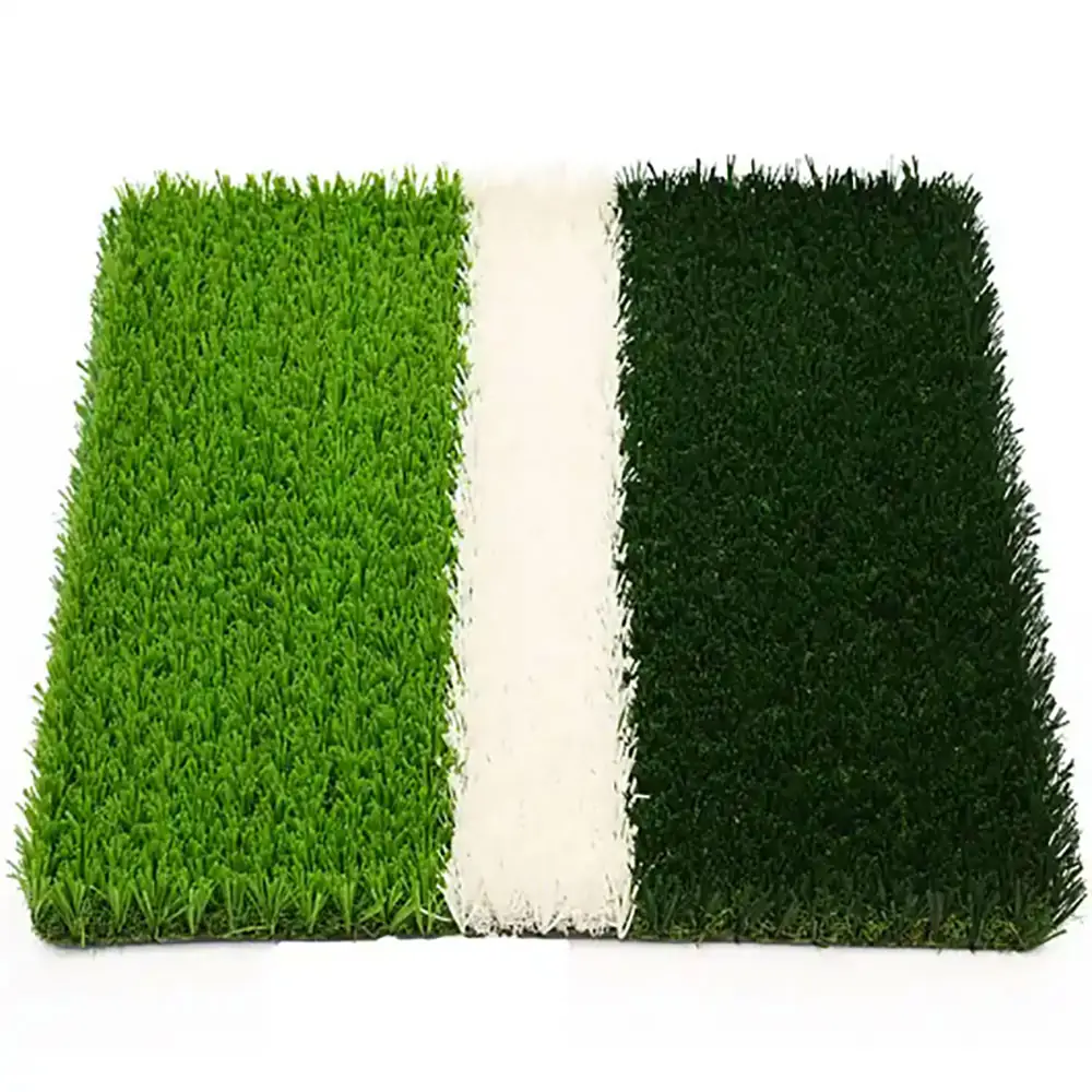 close up of artificial football turf showing green grass fibers and a white field marking strip.